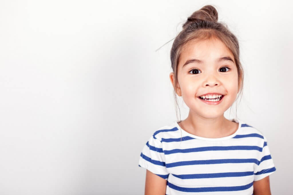 dental check ups for primary students, happy girl in striped top smiling