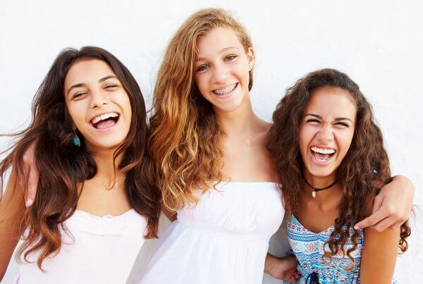 Free dental services for teens, three teenage girls smiling