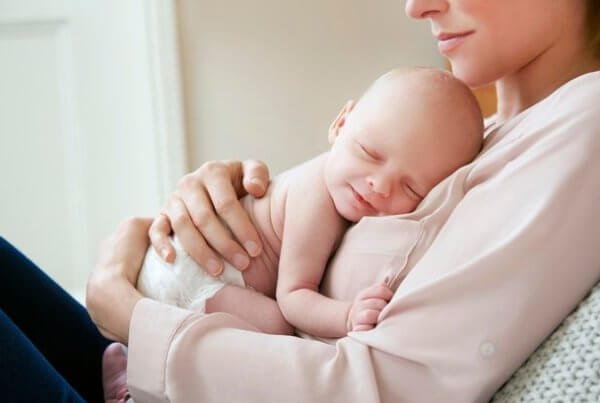 New mums and oral health, oral health during pregnancy, baby sleeping on mother's chest