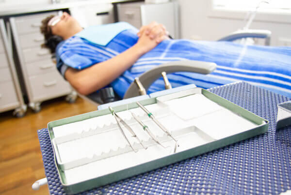 Sleep dentistry, patient sedated in dentist chair