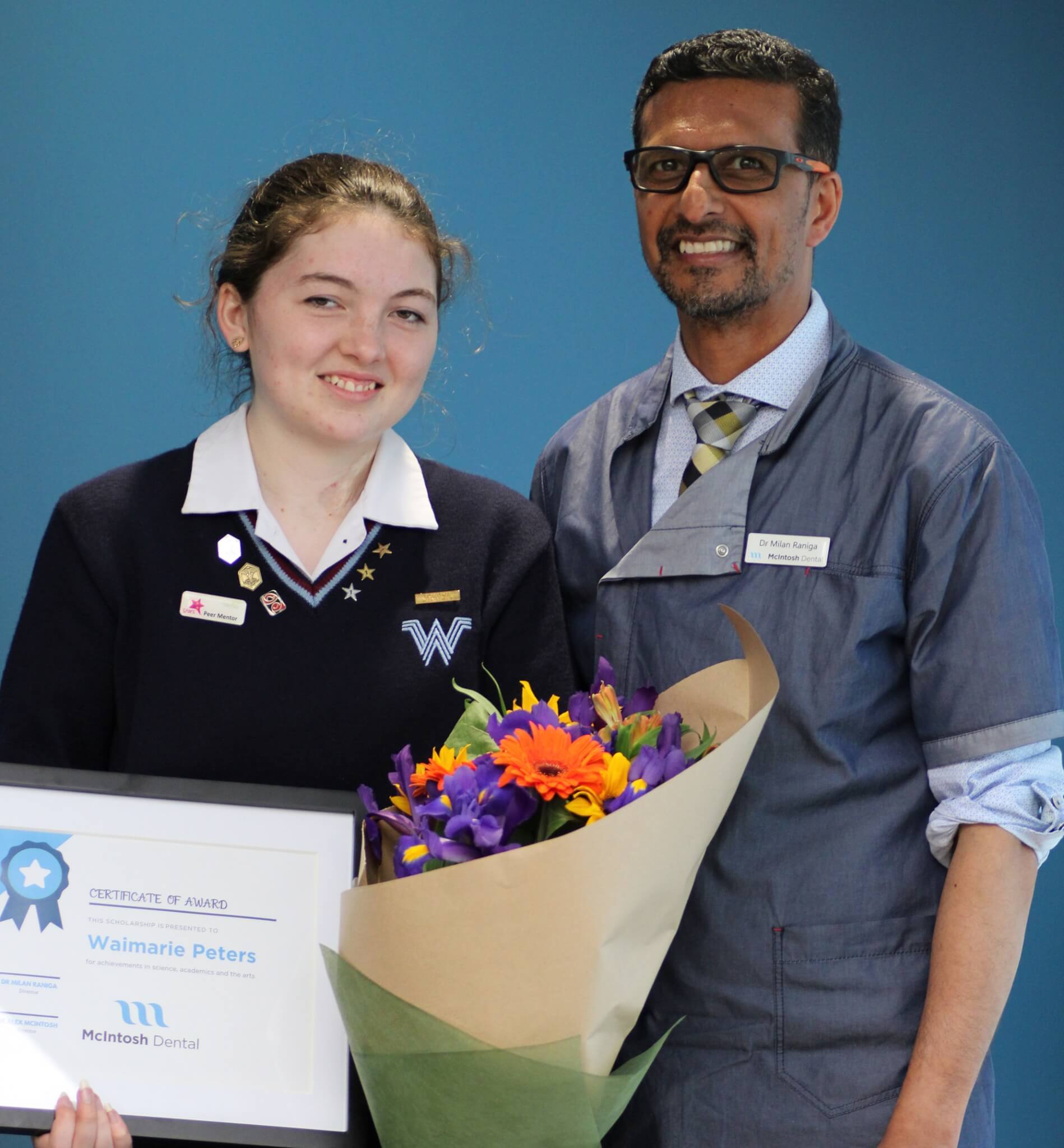 Orthodontic scholarship winners 2020, teenage girl holding certificate and flowers with orthodontist