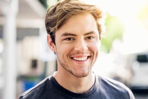 Reasons to see your dentist, young man smiling