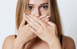 get rid of bad breath, woman holding hands over her mouth