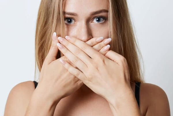 get rid of bad breath, woman holding hands over her mouth