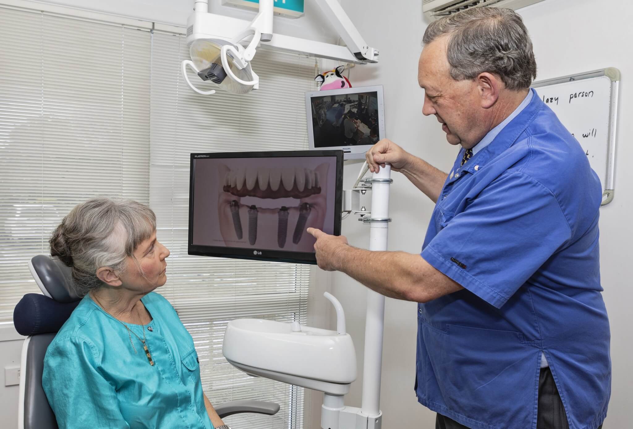 Dental implants, questions you should ask before getting a dental implant, patient with implant dentist