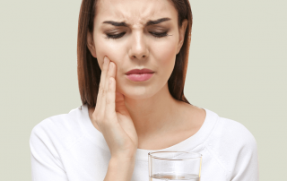 Teeth sensitivity, woman with sensitive teeth drinking glass of water