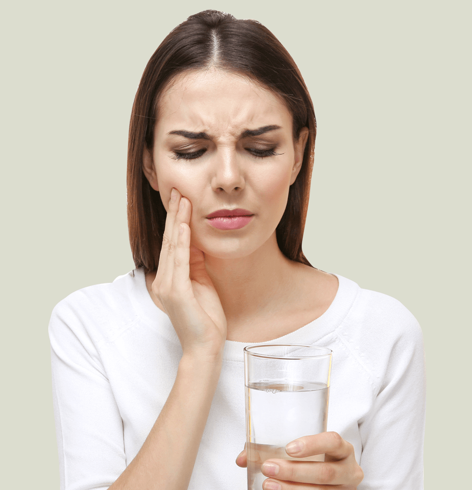 Tips for sensitive teeth, woman with sensitive teeth drinking glass of water