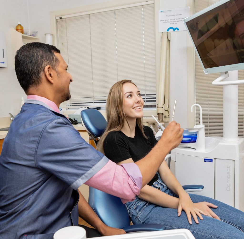 reasons to see your dentist every 6 months, dentist and patient looking at x-ray