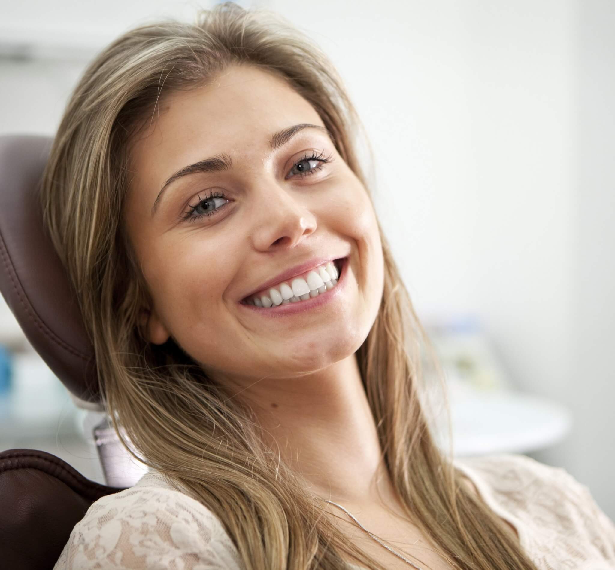 Reasons to consider cosmetic dentistry, woman with beautiful smile in dentists chair