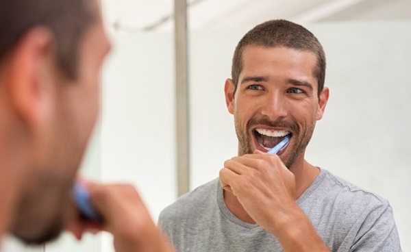 toothbrushing mistakes, man brushing his teeth