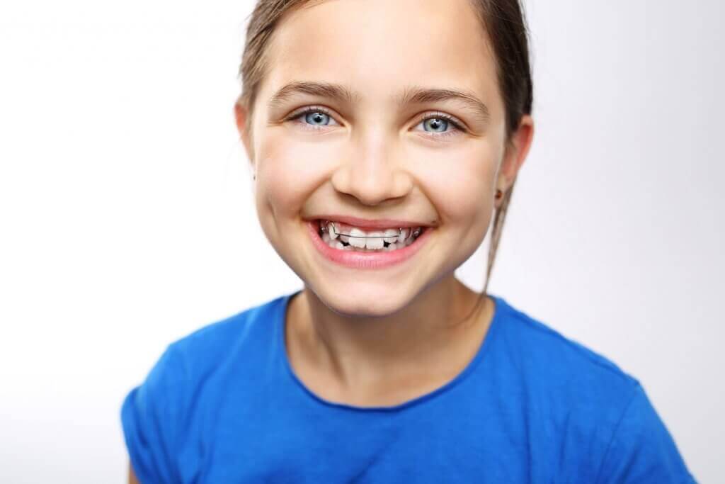 Stop bedwetting with orthodontics, girl smiling with orthodontic appliance