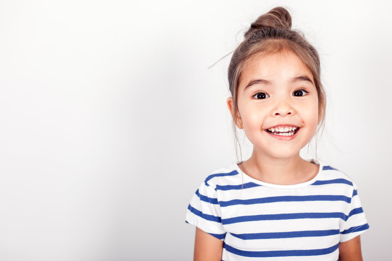 dental check ups for primary students, happy girl in striped top smiling